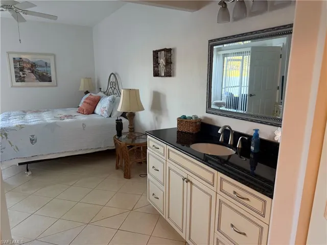 Bedroom with ceiling fan and light tile patterned floors