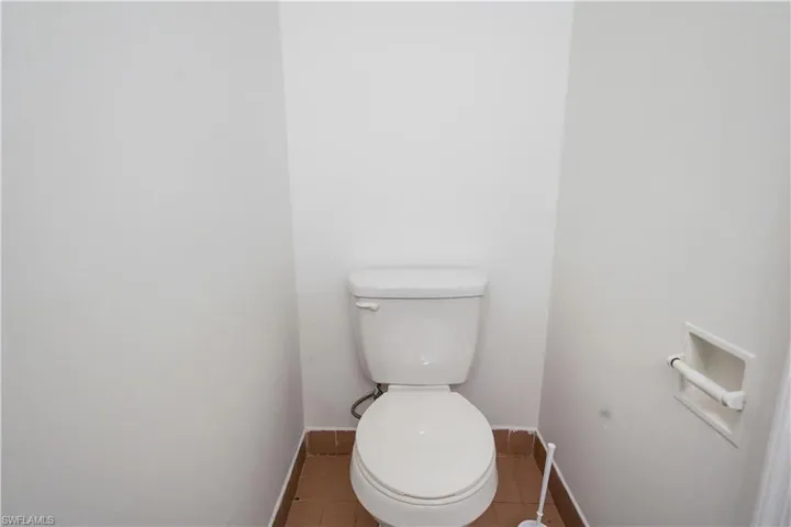 White two-piece toilet with a matching integrated toilet paper holder