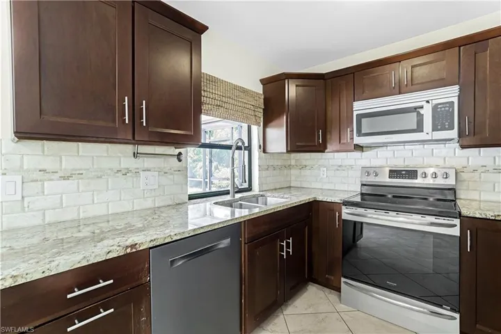 Kitchen with appliances with stainless steel finishes, backsplash, and sink