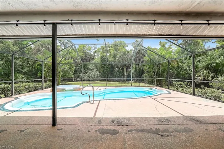 View of pool with a lanai and a patio area