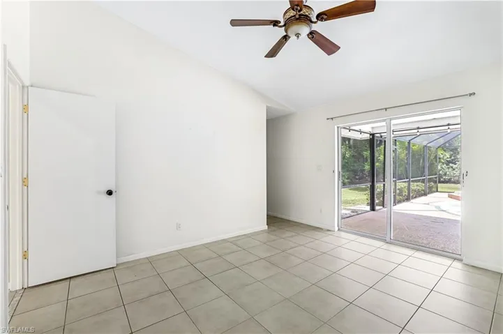 Spare room featuring light tile patterned flooring, ceiling fan, and vaulted ceiling