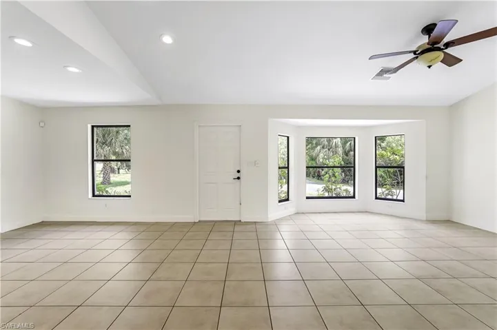 Tiled spare room featuring ceiling fan