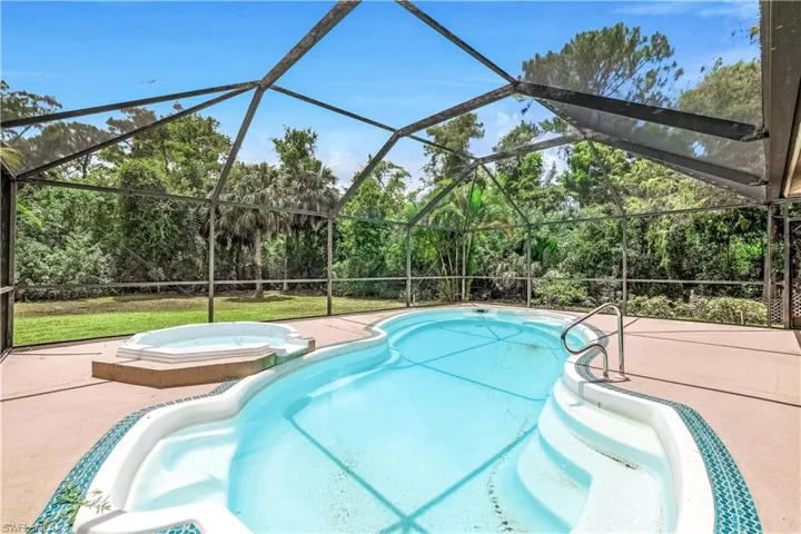 View of pool with a patio, an in ground hot tub, and a lanai