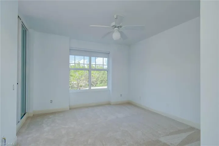 Guest Bedroom featuring light colored carpet and ceiling fan facing Front Balcony
