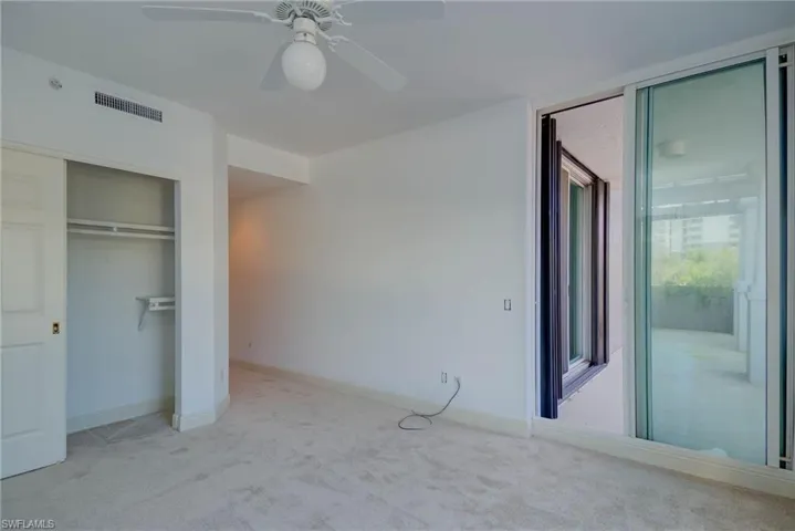 3rd Bedroom with carpet floors, ceiling fan, and a closet. Sliders to Front Balcony - Private Bath