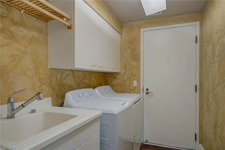 Laundr room featuring washer and dryer and cabinet space. Back door leads to Hall and Service Elevator.