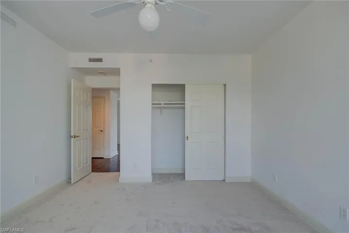 Unfurnished bedroom with carpet floors, a closet, and a ceiling fan