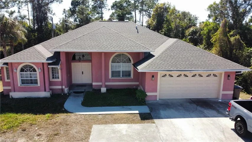 View of front of property featuring a shingled roof, driveway, a garage, covered porch, and stucco siding
