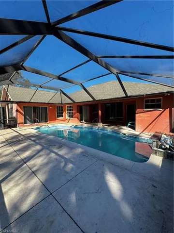 Swimming pool featuring a lanai, a sunroom, and a patio