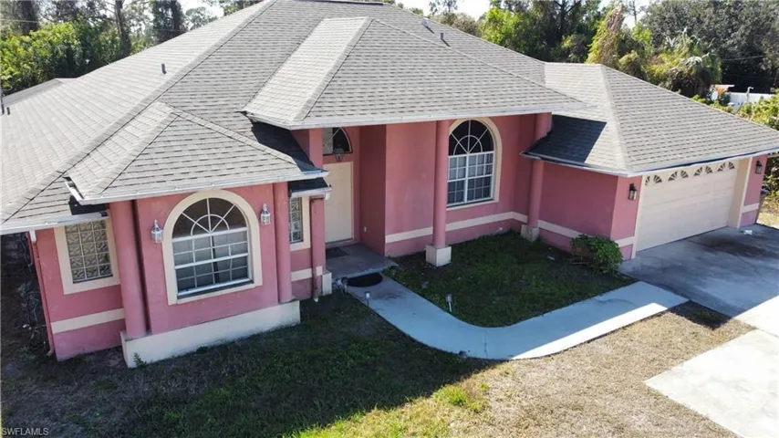 View of front of home featuring a shingled roof, driveway, an attached garage, and stucco siding