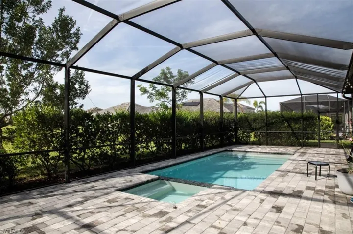 View of pool with a lanai, a sunroom, a pool with connected hot tub, and a patio area