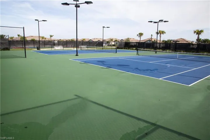 View of tennis court with community basketball court and a residential view