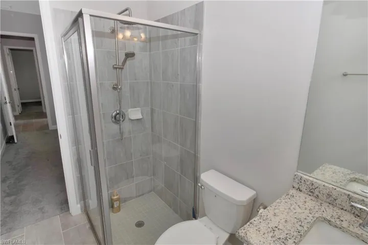 Full bath with a stall shower, vanity, and light tile patterned floors