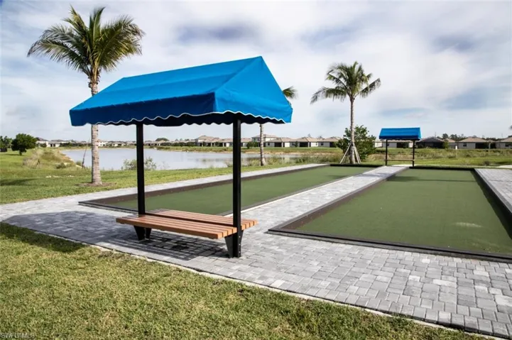 View of property's community with a game area, a lawn, a residential view, and a water view