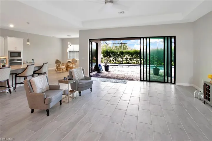 Living area with healthy amount of natural light, wood tiled floors, and ceiling fan