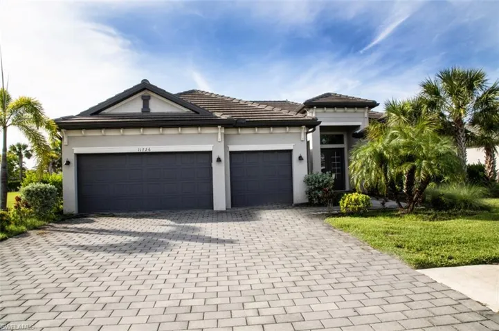 View of front of house featuring decorative driveway, a garage, and stucco siding