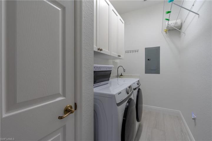 Laundry off kitchen with lots of storage and utility sink