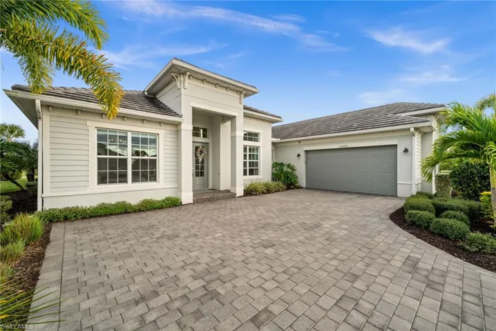 View of front of home featuring decorative driveway, stucco siding, a garage, and a tiled roof