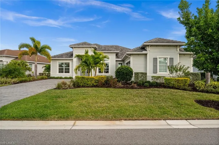 View of front of property featuring a front lawn, stucco siding, and decorative driveway