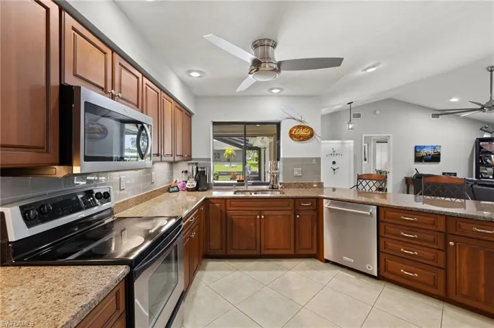 Kitchen with lofted ceiling, sink, ceiling fan, and stainless steel appliances