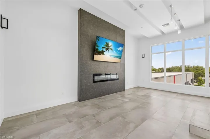 Unfurnished living room featuring a fireplace and baseboards