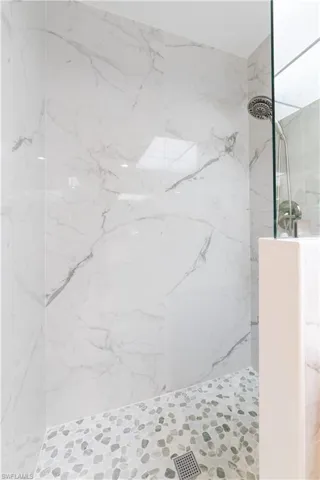 Full bathroom with a marble finish shower