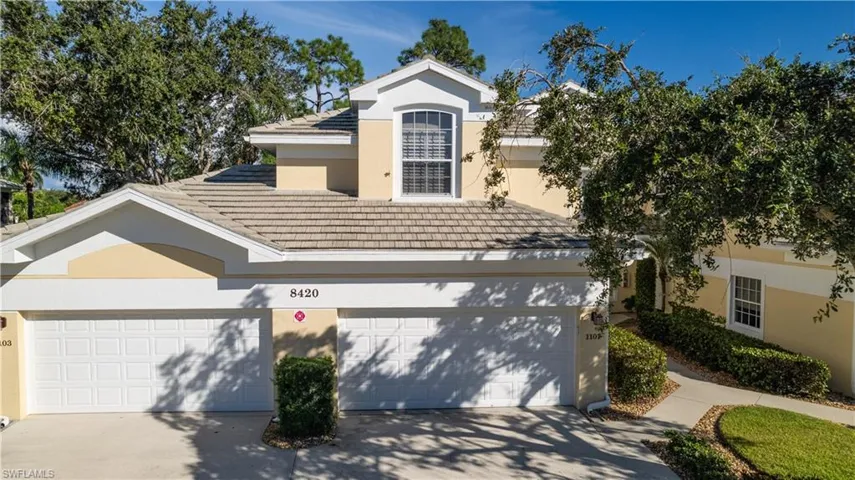 View of front of property featuring driveway, a tile roof, and stucco siding