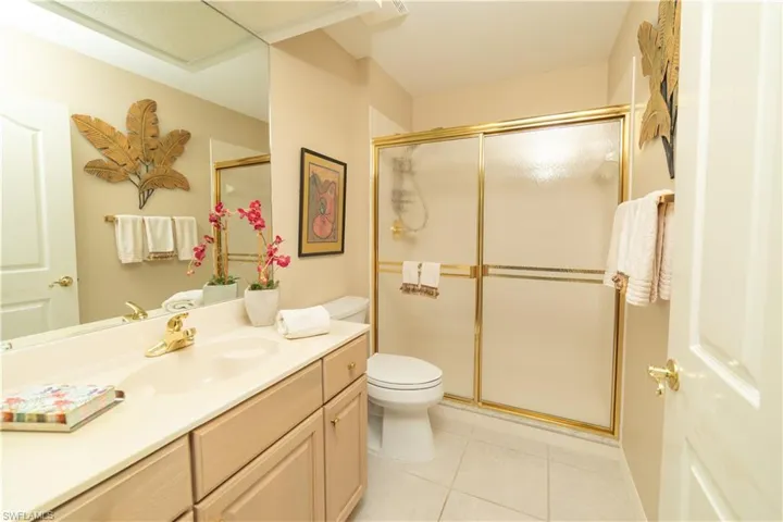 Full bath with vanity, light tile patterned flooring, and a stall shower