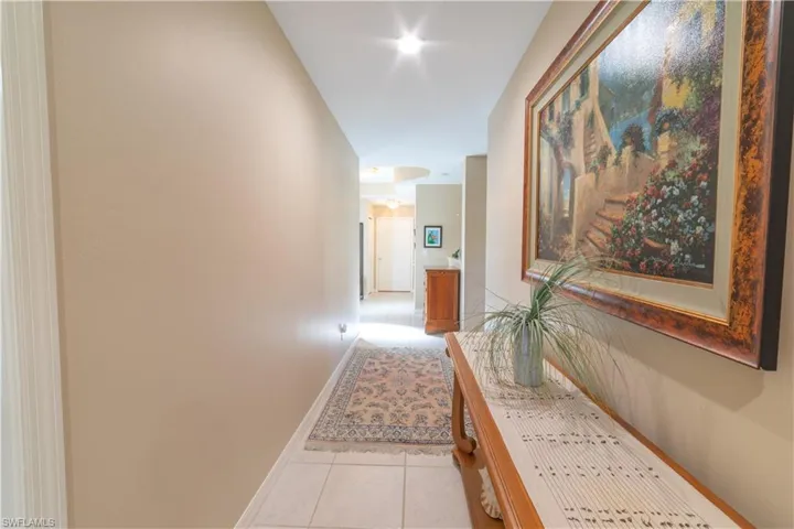 Corridor featuring light tile patterned floors and baseboards