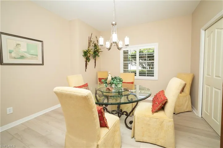 Dining room with light wood-style floors and a chandelier