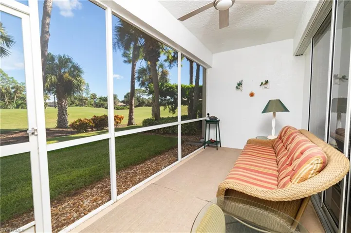 Sunroom / solarium with ceiling fan and view of golf course
