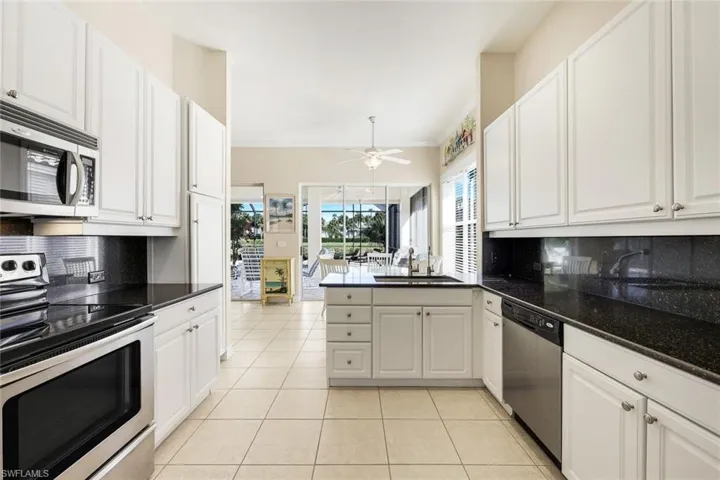 Kitchen with backsplash, appliances with stainless steel finishes, white cabinetry, a peninsula, and ornamental molding