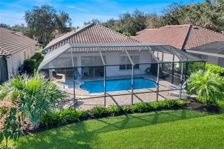 Swimming pool with a sunroom, a lanai, a patio, and a lawn