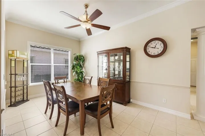 Dining space with ornamental molding, light tile patterned floors, and a ceiling fan