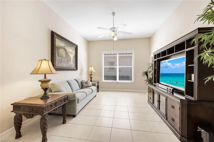 Living area with light tile patterned floors and ceiling fan