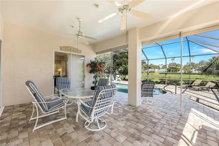 View of patio / terrace with ceiling fan, a sunroom, outdoor dining space, an outdoor pool, and a lanai
