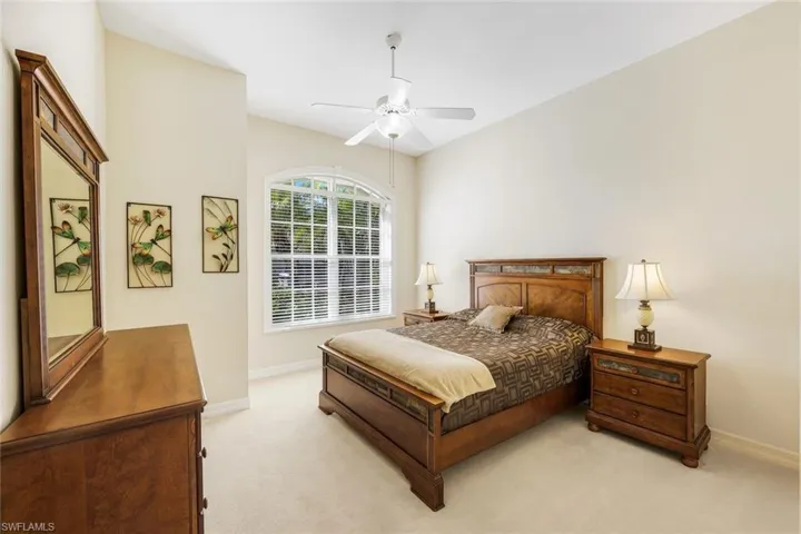 Carpeted bedroom with baseboards and a ceiling fan