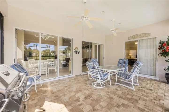View of patio with outdoor dining area, grilling area, and a ceiling fan