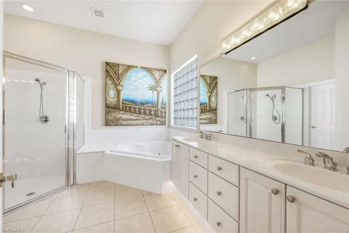 Bathroom with double vanity, a stall shower, a garden tub, light tile patterned flooring, and recessed lighting