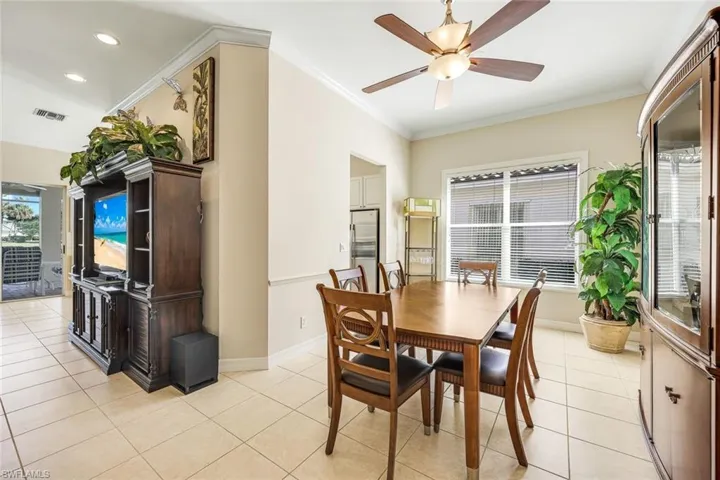 Dining area with crown molding, a ceiling fan, light tile patterned floors, and recessed lighting