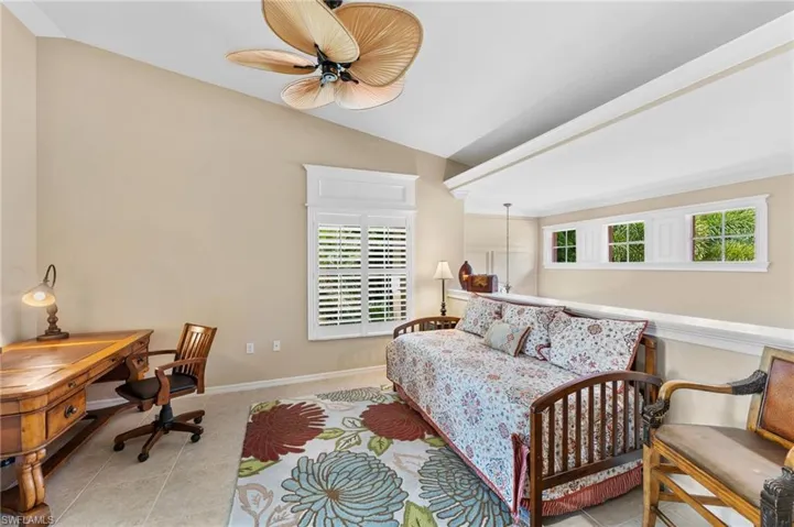 Tiled bedroom with lofted ceiling and ceiling fan