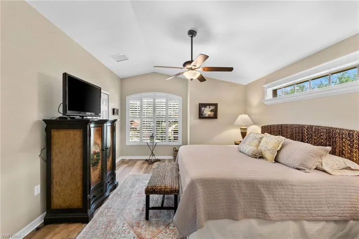 Bedroom featuring wood-type flooring, ceiling fan, and lofted ceiling