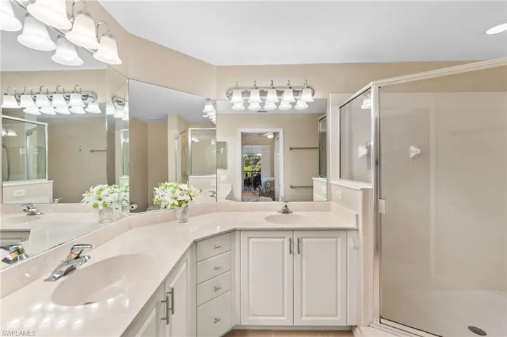 Bathroom with dual vanity and an enclosed shower