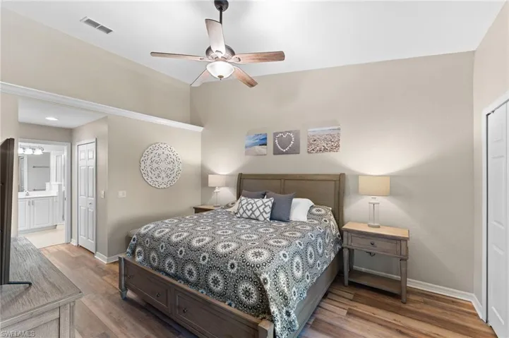 Bedroom with ensuite bath, ceiling fan, hardwood / wood-style flooring, and a closet