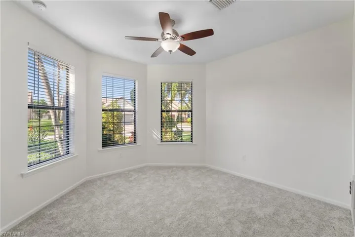 Carpeted empty room with ceiling fan