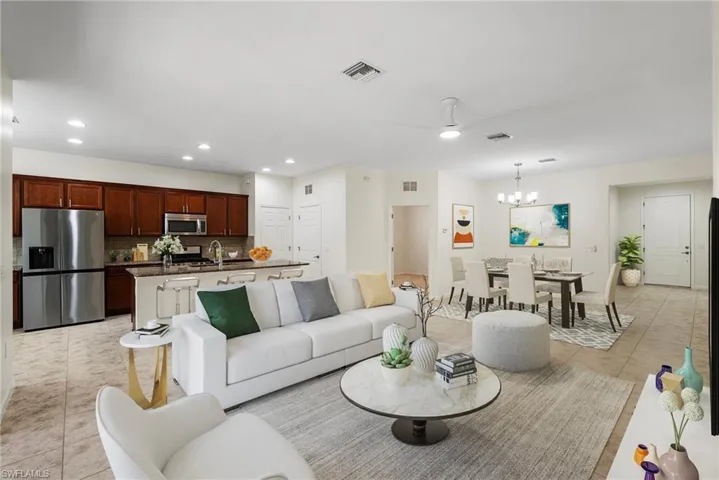 Living room with ceiling fan with notable chandelier and light tile patterned floors
