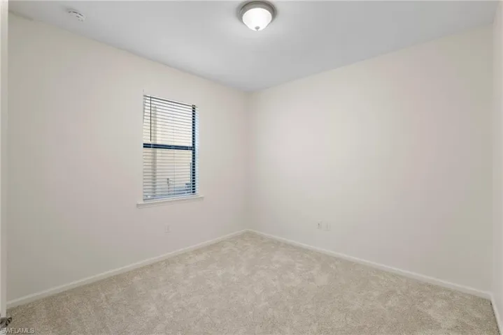 Empty room featuring light colored carpet