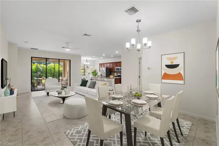 Tiled dining area featuring ceiling fan with notable chandelier