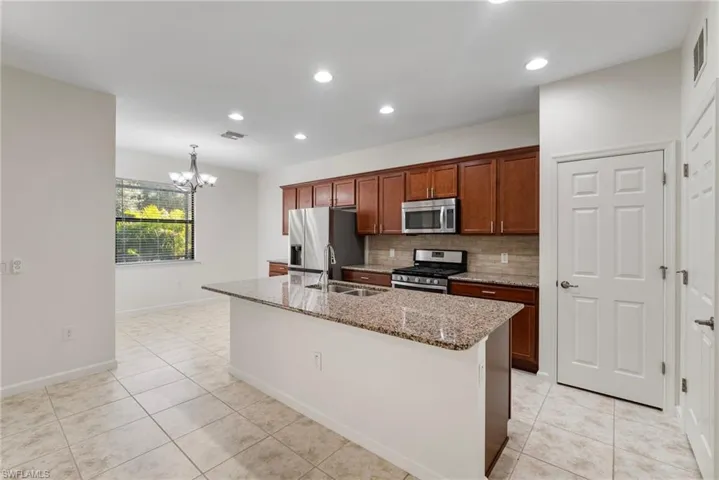 Kitchen featuring tasteful backsplash, stainless steel appliances, and light tile patterned floors
