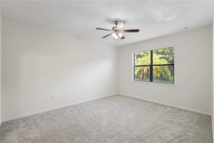 Spare room with ceiling fan and carpet flooring